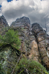 Mighty rock formation in a forest under a dramatic sky, natural monumental.