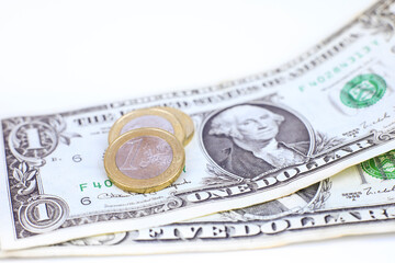 Euro coins and dollar bills on white background