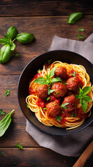 Delicious spaghetti with meatballs served in a rustic bowl surrounded by fresh basil