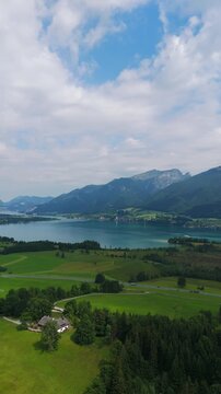 Aerial vertical travel view, Alpine landscape in Lake Wolfgangsee and Strobl Town in the Salzburg Region During Summer, traffic in countryside location of Austria