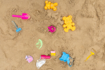 Abandoned old toys on a playground with sand. Top view