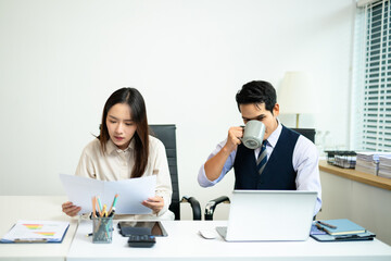 Professional team collaborating in office, using tablet and laptop, with coffee in hand showcasing...