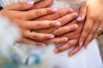 Fototapeta premium Bride and groom showing wedding rings embracing each other