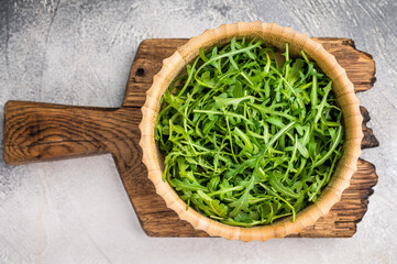 Fresh arugula leaves, vibrant and peppery, perfect for adding a zesty touch to salads and sandwiches. grey background. top view