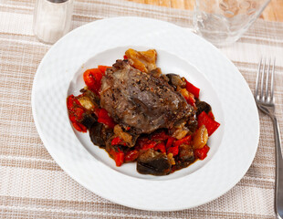 Appetizing roasted pork loin served with vitamin vegetable garnish of baked eggplants with bell peppers, onions and carrots