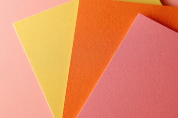 Three sheets of vibrant, pastel-colored paper layered and angled