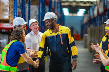 Male industrial worker receives applause and recognition from multicultural team. Great for HR campaigns, teamwork, and leadership visuals.
