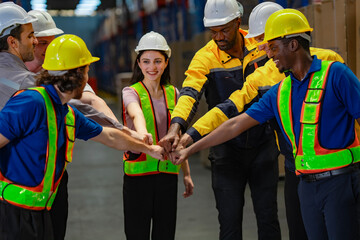 Enthusiastic warehouse team symbolically stacks hands in a circle, reinforcing collaboration, focus, and a shared sense of direction in an industrial or logistics work setting.