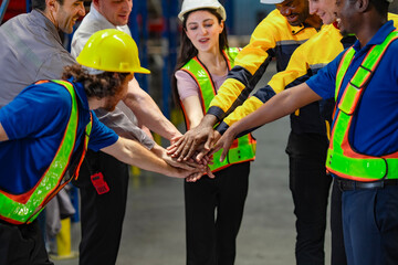Focused team in logistics center performs a symbolic hand stack to express commitment, reliability,...