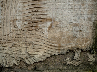 Abstract old unkempt background with uneven plaster. The surface shows striped indentations and a square grid.