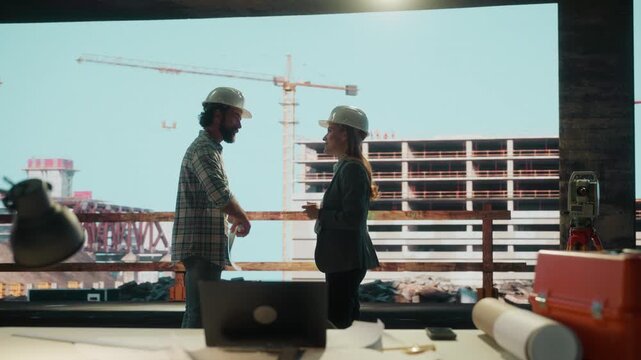 Construction site meeting: engineers discussing and shaking hands