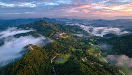Misty mountain range at sunrise with golf course