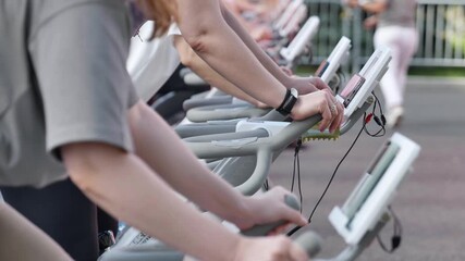 Athletes pedaling on exercise bikes during sports day