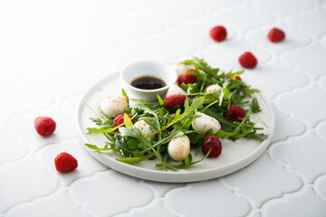 Arugula salad with mozzarella and raspberry