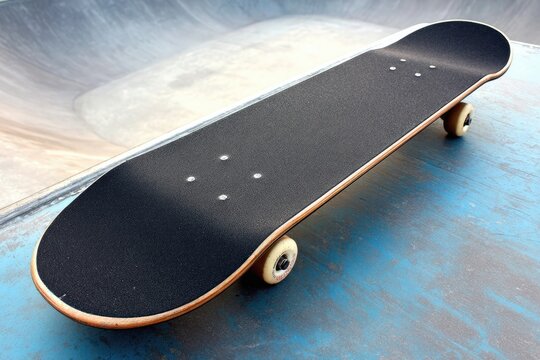 Skateboard atop a concrete skatepark ramp