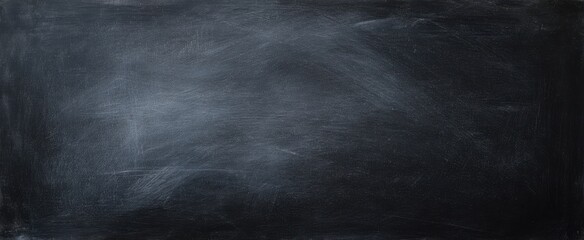Obraz premium The textured black background featuring a smooth chalkboard surface for creative use.