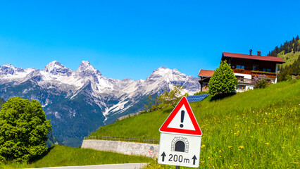 Alm Huts with mountain views tunnel road sign Austria. © Arkadi