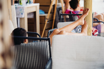 A young woman in a bright orange swimsuit relaxes at a table in a summer bar