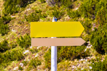 Yellow arrow location and hiking sign direction in Tyrol Austria.
