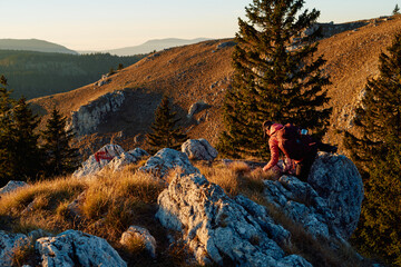 A female mountaineer, equipped with professional gear, enjoys the thrill of her climb as she...