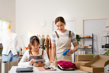 Asian partner startup small business owner packing goods for delivery to clients.