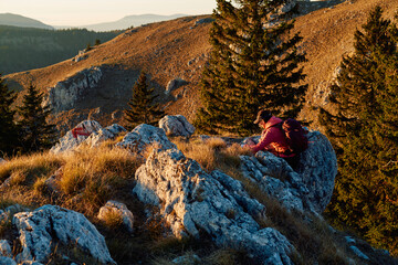 A female mountaineer, equipped with professional gear, enjoys the thrill of her climb as she...