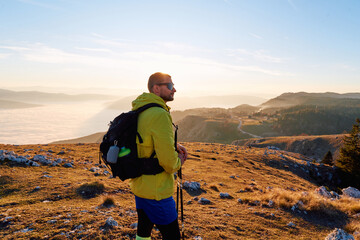 An extreme mountaineer, equipped with professional gear, pushes towards the peak of the mountain at...