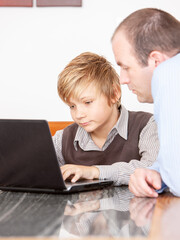 Family Life, Help with Homework. A young boy using a laptop computer to work on his schoolwork...