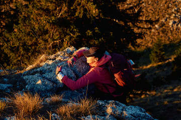 A female mountaineer, equipped with professional gear, enjoys the thrill of her climb as she...