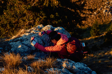 A female mountaineer, equipped with professional gear, enjoys the thrill of her climb as she...