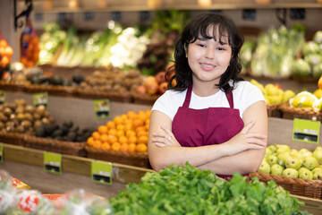 Portrait of friendly smiling female employee of a grocery supermarket with parsley