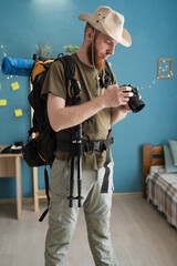 man photographer with big backpack preparing to hike in mountains. Travel and hobby