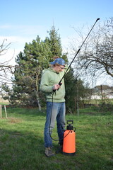 Young man engaged in household chores and small-scale rural farming, tending to his garden with...