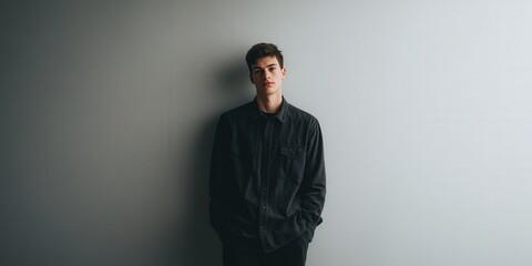 Obraz premium Stylish Young Man in Casual Attire Posing Against a Minimalist Background