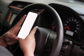 Person holding a smartphone with a blank white screen inside a car. Mockup for a mobile app or GPS...