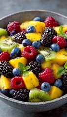 Obraz premium Refreshing Summer Fruit Salad with Mango, Berries, Kiwi, and a Hint of Mint for a Tropical Delight