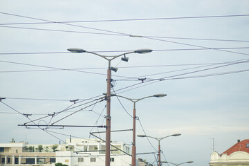 Chaotic network of electric wires and streetlights in urban scene. Wirescape: visual disorder in...