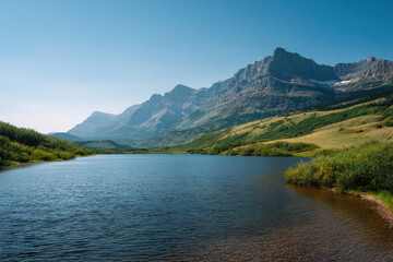 breathtaking summer landscape in saskatchewan featuring serene mountain lake surrounded by lush greenery