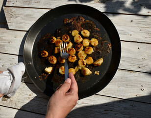 Woman hand with fork while fried bananas preparation process. 