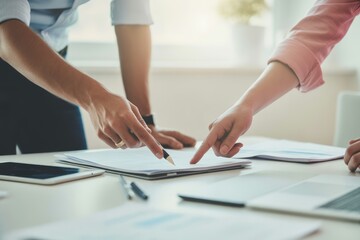 People pointing at documents during meeting hands