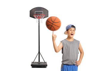 Joyful boy spinning a basketball with his finger