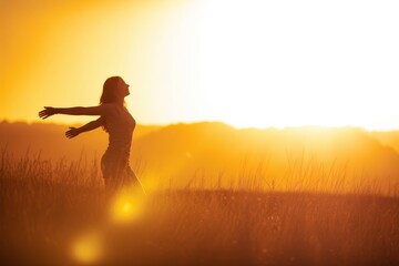 Fototapeta premium Woman arms outstretched golden hour silhouette sunset