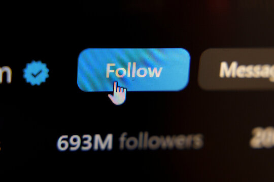 Mouse cursor clicking the blue Follow button on a verified social media profile