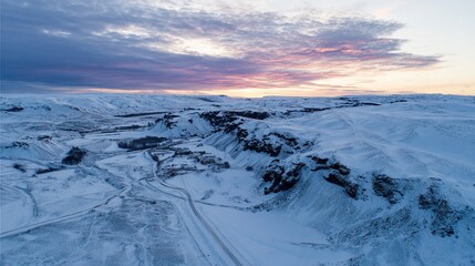 A drone photo of the sun setting over a snow-covered Icelandic landscape. 