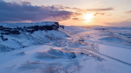A drone photo of the sun setting over a snow-covered Icelandic landscape. 