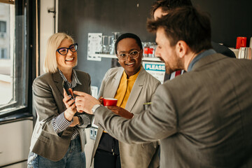 Business team sharing engaging content on smartphone during office break