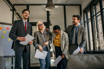 Happy business team laughing together after successful presentation in office