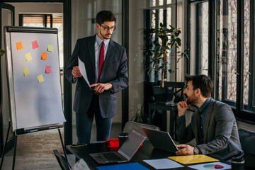 Businessman leading meeting with presentation in modern office