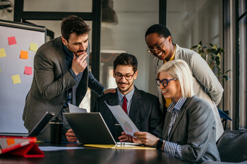 Business people working together on a project using laptop and documents
