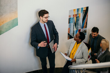 Business people discussing while walking down the stairs in office hall